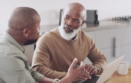 4k video footage of a senior man using a laptop with his son at home