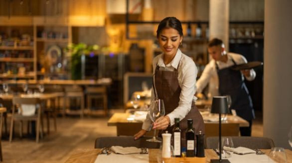 Beautiful waitress working in luxury hotel restaurant.